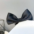 Detailansicht einer schwarzen Satin-Schleifen-Haarklammer mit robustem Metall-Clip - Schwarz