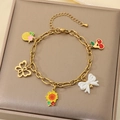 Golden stainless steel bracelet with cherry and pineapple charms on a jewelry display pad - Pineapple Cherry Bow Sunflower Butterfly Style(KB203460-Z)