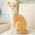 Realistisches orangefarbenes Katzen-Stofftier in sitzender Pose auf einem Sofa - 20cm / Sitzende Orangefarbene Katze