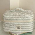 Quilted cotton makeup bag with green stripes and handle on aesthetic book stack - Makeup Bag / Green