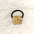 Black elastic hair tie with a textured square golden alloy charm on white background - Gold Square Lava 3.5cm
