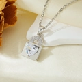 Macro shot of a silver heart lock pendant with zircons resting on white stones - Silver White Zircon Lock Heart Necklace (T021)