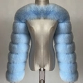 Close-up of light blue faux fur bolero shrug featuring thick segmented plush texture - One Size / Blue