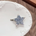 Detailed view of Y2K star-shaped hair clip with blue rhinestones on a white plate - Full Zirconia Pentagram / Blue