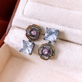 Macro shot of asymmetric flower earrings with pink and orange gemstones in a jewelry box - Asymmetric Flower and Square Style / Vintage Black Gold - Multicolor Zircon