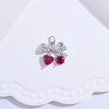 Macro detail of cherry-shaped bow pendant with red heart gems and sparkling silver setting - Silver Bowknot Cherry