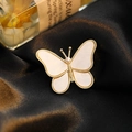 Elegant gold butterfly brooch with pearl wings and crystal accents on silk background - Butterfly