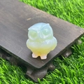 3.5cm natural opal stone owl figurine carving on a dark wooden base with garden background - Opal