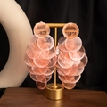 Detailed view of layered pale pink shell petal drop earrings on a golden display stand - S4763-1 Style / Orange