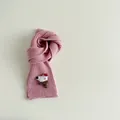 Close-up of pink ribbed knit kids scarf with cute cartoon dog and mushroom patch - Pink