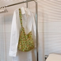 Détail d'un sac en coton vert à fleurs de tulipes rouges accroché à un cintre en métal - Base Vert Fruit Petite Fleur Orange