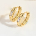 Macro detail of gold croissant hoop earrings with twisted texture and rectangle zircon - Rectangular Zirconia Style