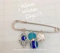 Close-up of Hamsa hand and blue Evil Eye charms on silver-plated decorative brooch pin - Zirconia Inlaid / Silver