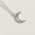 Silver crescent moon pendant necklace with white cubic zirconia stones on stone surface - Large Silver