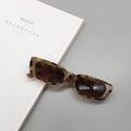 Detailed macro view of tortoiseshell rectangular sunglasses with dark grey lenses - Tortoise