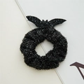 Detail eines schwarzen Halloween-Haargummis mit Glitzerstoff und glänzenden Fledermausflügeln - Kleiner Glänzender Fledermaus Haargummi