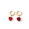 Détail de boucles d'oreilles créoles dorées avec pendentifs cœur rouge translucide - Or + Rouge