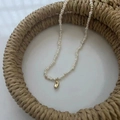 Baroque freshwater pearl necklace with a smooth golden bean pendant in a straw tray - Gold Bean Fine Rice Pearl