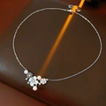 Detailed view of silver flower pendant necklace with white pearls on brown leather - Silver