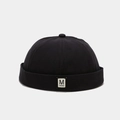 Detail van de zwarte docker muts zonder rand met een wit M FASHION geweven label patch - Verstelbaar / Zwart