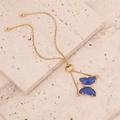 Macro detail of 18K gold box chain bracelet with blue gemstone butterfly pendant - Dark Blue