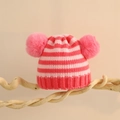 Nahaufnahme der rosa gestreiften Baby-Strickmütze mit zwei Pompons auf einem Holzständer - Einheitsgröße (1-5 Jahre) / Rosa