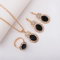 Golden bridal jewelry set with oval black gems and sparkling rhinestones on white fabric - Three-Piece Set / Oval Black