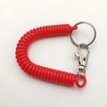 Red flexible plastic spiral spring keychain with metal clasp on white background - Red