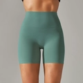 Close-up of high-waisted fitness shorts in sage green featuring seamless brushed fabric - Bright Green