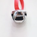 Close-up of 38mm silver metal bell with Dream engraving and red silk ribbon loop - DREAM