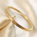 Sottile bracciale rigido in acciaio dorato con motivo a greca su seta champagne - 4mm / Oro