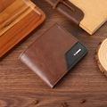 Close-up of brown leather wallet with black triangle patchwork and silver metal logo plate - Coffee