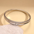 Details eines versilberten Armreifs mit Herzakzent und funkelnden Zirkonia-Steinen - Silber