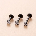 Tre piercing labret neri in acciaio con zirconi chiari da 3mm in uno scatto di dettaglio - Nero