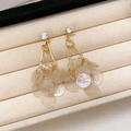 Detail van gouden kwastjes oorbellen met stras en iriserende lovertjes op fluweel - 36# Zilveren Pin - Goud - Wit - Schelp
