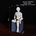 Statua moderna in resina di lettore con scritte nere che tiene un libro giallo - Posa Seduta Lettura A539-0012