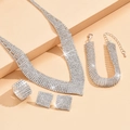 Elegant 4-piece silver bridal jewelry set with sparkling rhinestones on tiered display - Necklace + Earrings + Bracelet + Ring 4-Piece Set