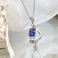 Detailed close-up of a blue enamel suitcase and silver airplane pendant on a chain - Silver - Suitcase Airplane Necklace