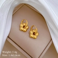 Detailed view of golden flower-shaped titanium steel earrings in a jewelry box - Titanium Steel Gold (T229)