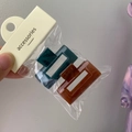Detail view of dark green and brown rectangular resin hair clips in packaging - Small Square (Peacock Blue + Coffee)