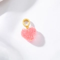 Dettaglio del ciondolo a cuore rosa strutturato con gancio dorato e piccoli diamanti - Rosa scuro