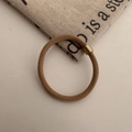 Close-up of high elasticity khaki hair tie with knitted texture and gold metal clasp - Brown