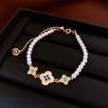 Gros plan d'un bracelet de perles avec trèfle bleu dans un écrin à bijoux noir - Bracelet en perles avec trèfle à quatre feuilles doré texture pierre bleue