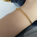 Primer plano de una pulsera de cordón de oro de alta calidad en la muñeca sobre fondo azul - Pulsera de Cadena de Cuerda / Dorado