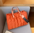 Gesteppte orangefarbene Nylon-Tragetasche mit rosa Griffen und blau gemustertem Gurt - Orange