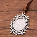 Antique silver oval pendant tray with floral border and brown woven cord - Flower Inlay Oval Style