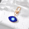 Macro shot of evil eye keychain with blue enamel inlay on a textured stone surface - 5# Dark Blue Pointed Eye
