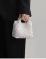 Detail view of a white hand-woven mini bucket bag with a soft textured finish - White