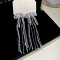 Detailed close-up of zircon bow earrings with long sparkling tassels on a black background - Silver Bow Tassel