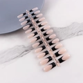 Detail of long ballerina press-on nails with black French tips on white marble surface - French Black Tip Long Coffin Glossy (CFX-MP02)